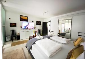 a bedroom with a large white bed and a television at Coresi Escape Studio in Sînpetru