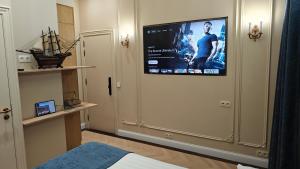 a room with a tv on a wall with a bed at Strands Of Time Hotel Bruges in Bruges
