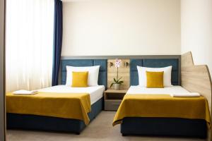 普罗夫迪夫SPS酒店的房间里有两张床，床的颜色是黄色和蓝色。