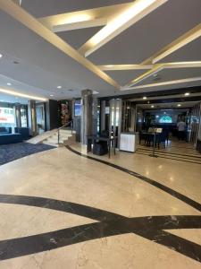 um átrio de um edifício com uma mesa e cadeiras em Asto Hotels Kuala Lumpur em Kuala Lumpur