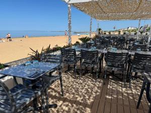 a group of tables and chairs on the beach at Acadie Saint Victor - Hôtel restaurant -Face mer- Châtelaillon plage in Châtelaillon-Plage +38 photos
