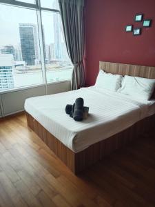 a bedroom with a bed with a book and a window at Vortex suites klcc by yana in Kuala Lumpur