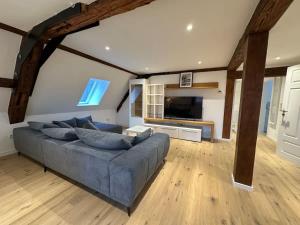 a living room with a blue couch and a television at Juraperle - Historisch und modern - Wohnung 2 in Bad Staffelstein +41 photos
