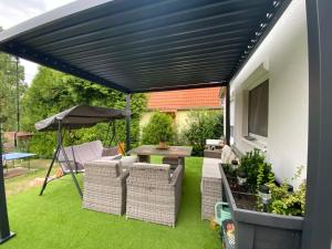 awning over a patio with a table and chairs at Gold Frog Apartman in Abaliget