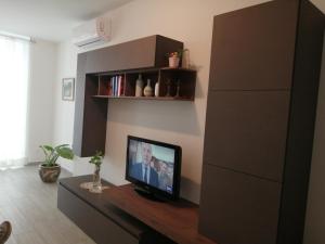 Una sala de estar con un televisor de pantalla plana sobre una mesa. en Suite Petit, en Vairano Scalo