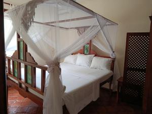 a bedroom with a canopy bed with white curtains at Vera Cruiz one bedroom CBD in Malindi