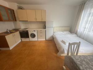 Una pequeña habitación con una cama y una cocina. en Studio Cathedral, en Varna