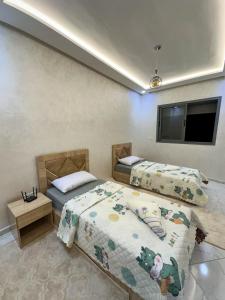 a bedroom with two beds and a flat screen tv at Spacious Apartment in heart of Agadir in Agadir