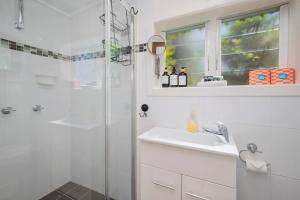 a white bathroom with a sink and a shower at Fairy Nook - Charming Granny Flat with Shared Garden in Mayfield