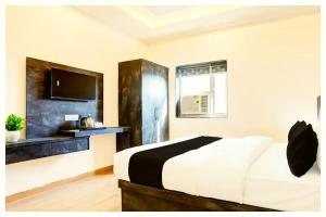 a bedroom with a bed and a tv on a wall at Hotel Ganraj Residency Near Laxmi Temple in Shirdi