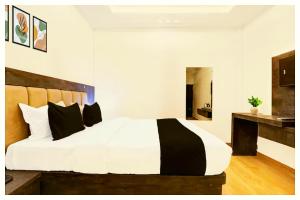 a bedroom with a large white bed with black pillows at Hotel Ganraj Residency Near Laxmi Temple in Shirdi