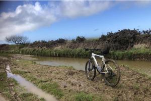 una bicicletta parcheggiata sul lato di un fiume di 1 Bedroom Cabin Sleeps 2 Private Garden WiFi a Camelford