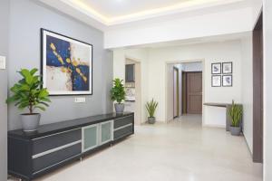 un pasillo con macetas y una pintura en la pared en FabExpress Shree Haree Residency - Nr Mazda Garden View, en Pune