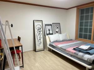 a bedroom with a bed and pictures on the wall at Harry House in Gyeongju