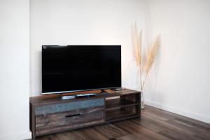 ミュールハイムにあるFerienwohnung am Bachの木製エンターテイメントセンターの上に座って薄型テレビを設置