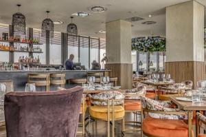 a restaurant with tables and chairs and a bar at Casa Vista One Rosebank in Johannesburg