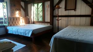 a bedroom with two beds and a window at Maia House Hostal in Florianópolis