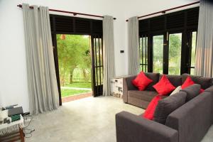 a living room with a couch with red pillows at Tranquile Viwe in Gonapinuwala West