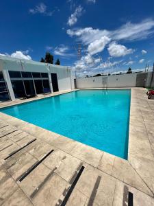 サンティアゴ・デ・ロス・カバリェロスにあるLuxury Pool Gym Basketballの建物の前の大きな青いプール