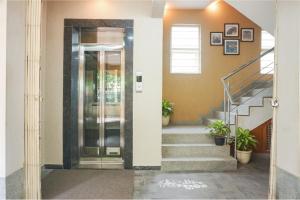 un pasillo con escaleras y una puerta con macetas en FabExpress Shree Haree Residency - Nr Mazda Garden View, en Pune