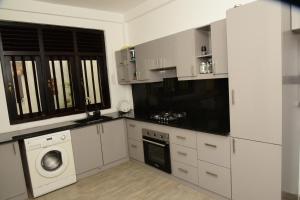 a kitchen with white cabinets and a washing machine at Tranquile Viwe in Gonapinuwala West +9 photos