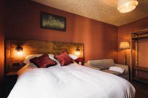 a bedroom with a large bed with red walls at Coaching Inn in South Molton