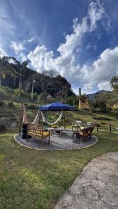 Un parque con bancos y un área de juegos con una sombrilla azul. en Pousada Casa Primitivus, en Pedra Menina 157 fotos más