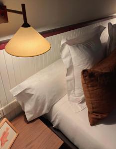a bedroom with a bed with white pillows and a lamp at Hotel Medium Montecarlo in Llafranc +9 photos
