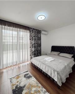 a bedroom with a bed and a large window at Luxury Penthouse 4 Bedrooms in Pristina