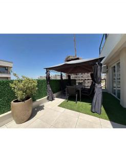a patio with a table and a large umbrella at Luxury Penthouse 4 Bedrooms in Pristina