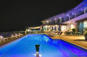 a swimming pool at night with chairs and tables at Hotel La Battigia in Alcamo Marina +125 photos