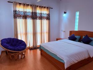 a bedroom with a bed and a chair and a window at Transit villa 10 minutes drive from the Airport in Katunayake