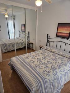 Un dormitorio con dos camas y un espejo. en Extraordinary apartment in Zahara de los Atunes, en Zahara de los Atunes