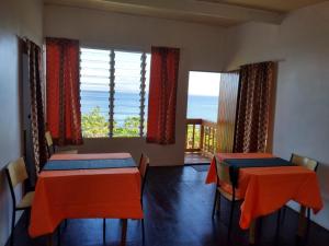two tables in a room with a view of the ocean at Tandra Island View Lodge 