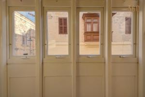 a pair of doors with windows in front of a building at Suite Victory Beautiful fully equipped 2BR Townhouse by 360 Estates in Birgu