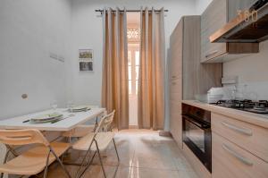 a kitchen with a dining table and a table and chairs at Suite Victory Beautiful fully equipped 2BR Townhouse by 360 Estates in Birgu