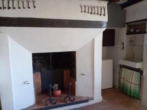 a living room with a fireplace with two metal objects at Gîte La Favorite à Oiron in Oiron