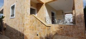 a stone building with a staircase and a balcony at Blue Ark Aigeira Flat & Studio in Aíyira
