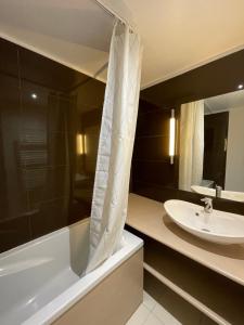 a bathroom with a bath tub and a sink at T3 Terrasse Piscine Sauna Spa Jausiers Magnans in Jausiers +20 photos