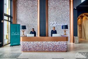 two people standing at a counter in a lobby at 22 Macalisterz by ALV in George Town +60 photos