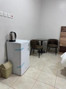 a room with a small refrigerator and chairs and a table at شقق مفروشة مكين 1 in Medina +60 photos