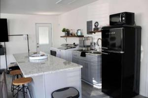a kitchen with a black refrigerator and a counter at Shore Nuff a relaxing 4-bedroom vacation home on Canyon Lake in Canyon Lake