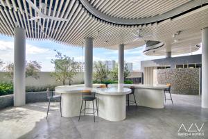 a lobby with two tables and chairs in a building at 22 Macalisterz by ALV in George Town
