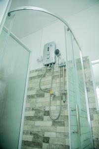 eine Dusche in einem Badezimmer mit Glasabtrennung in der Unterkunft Cottage Haven Villa in Galle