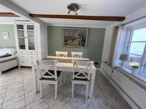 Un comedor con una mesa y sillas blancas. en Fischerkate in Massholm, en Maasholm