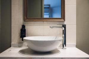 Un lavabo en un baño con espejo. en Coaching Inn, en South Molton 32 fotos más