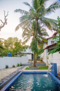 einen Pool vor einem Haus mit einer Palme in der Unterkunft Cottage Haven Villa in Galle