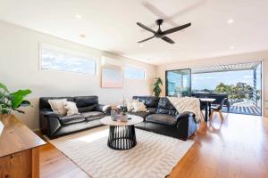a living room with a couch and a table and a piano at Spacious Seaview Family Getaway in Torquay