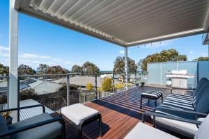 a deck with chairs and a grill on a house at Spacious Seaview Family Getaway in Torquay +19 photos