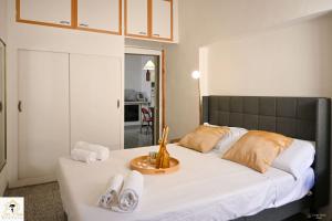 a bedroom with a large bed with white sheets and shoes at Inn Pisa Rentals 2 - Rustic Romantic Pisa Flat in Pisa